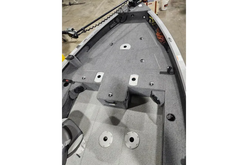 Slide: The Image of 2024 Lund 1875 Pro Guide boat interior with gray carpet and fishing rod holders. - 4