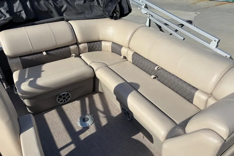 Slide: The Image of 2024 Sun Tracker Party Barge 20 DLX interior seating with beige upholstery and speaker. - 10