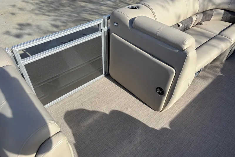 Slide: The Image of 2024 Sun Tracker Party Barge 20 DLX interior with beige seating and safety gate. - 13