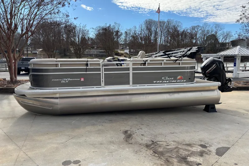 Slide: The Image of 2024 Sun Tracker Party Barge 20 DLX pontoon boat on display at a marina. - 3