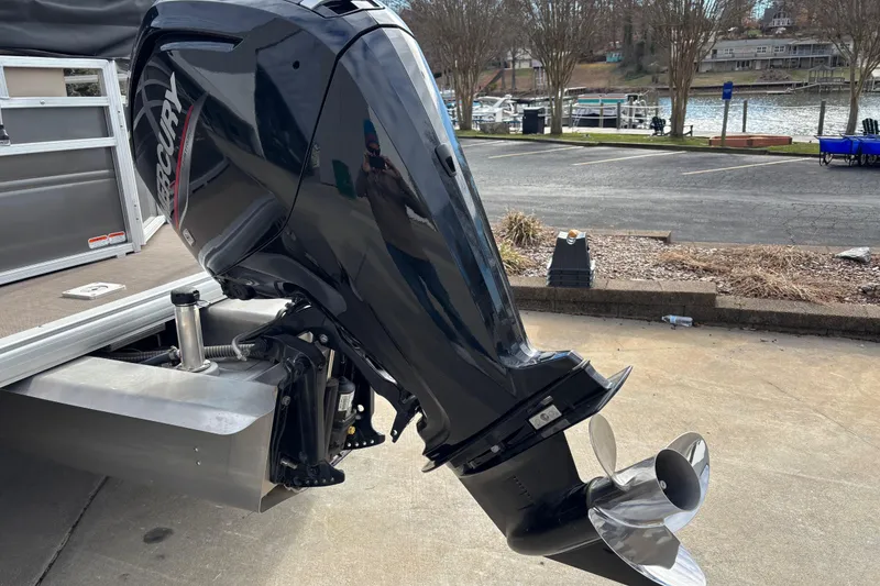 Slide: The Image of 2024 Sun Tracker Party Barge 20 DLX with Mercury outboard motor by a lakeside. - 7