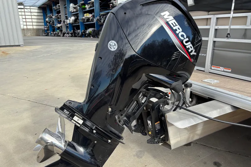 Slide: The Image of 2024 Sun Tracker Party Barge 20 DLX with Mercury outboard motor in storage facility. - 8