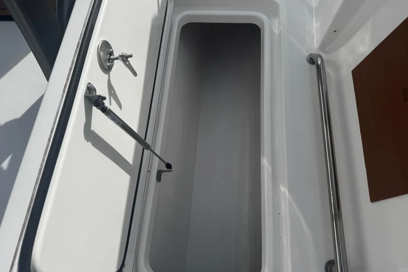 Slide: The Image of Open storage compartment on 2026 Sea Pro 262 Offshore boat, featuring stainless steel handle. - 14