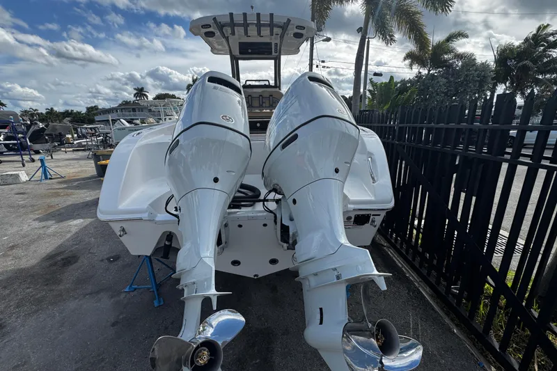 Slide: The Image of 2026 Sea Pro 262 Offshore boat with dual outboard motors, parked near palm trees. - 45