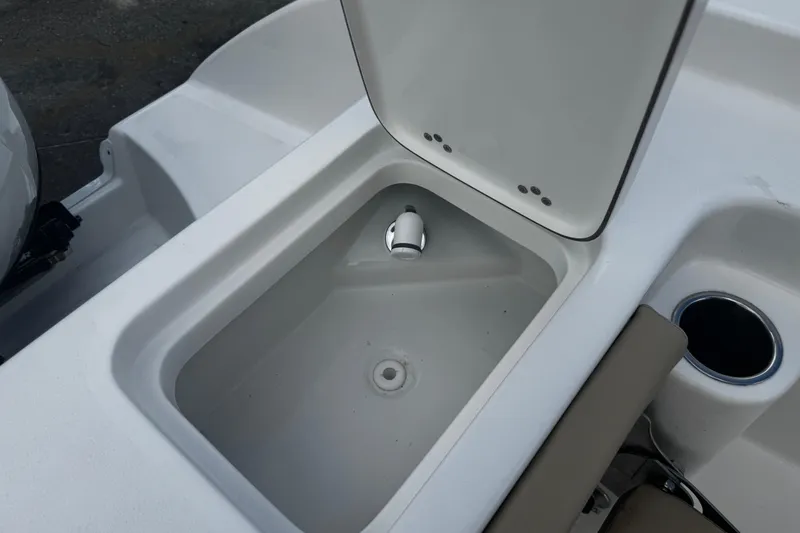 Slide: The Image of 2026 Sea Pro 262 Offshore boat compartment with open lid and cup holder. - 8