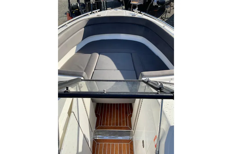 Slide: The Image of Interior view of 2017 Draco 22RS boat with cushioned seating and wooden flooring. - 16
