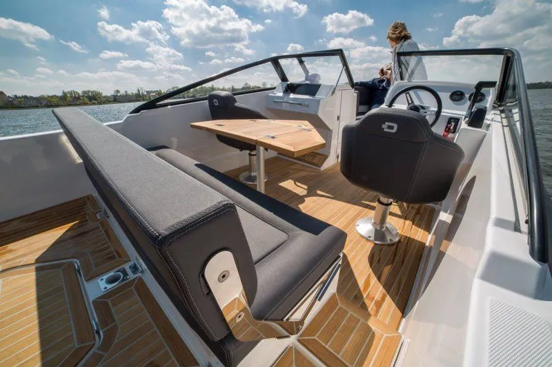 Slide: The Image of Manufacturer Provided Image: 2018 Draco 22RS boat interior with seating, table, and steering wheel on a sunny day. - 5