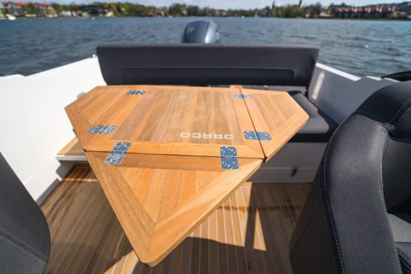 Slide: The Image of Manufacturer Provided Image: Draco 22RS 2018 boat interior with wooden table and lake view. - 6