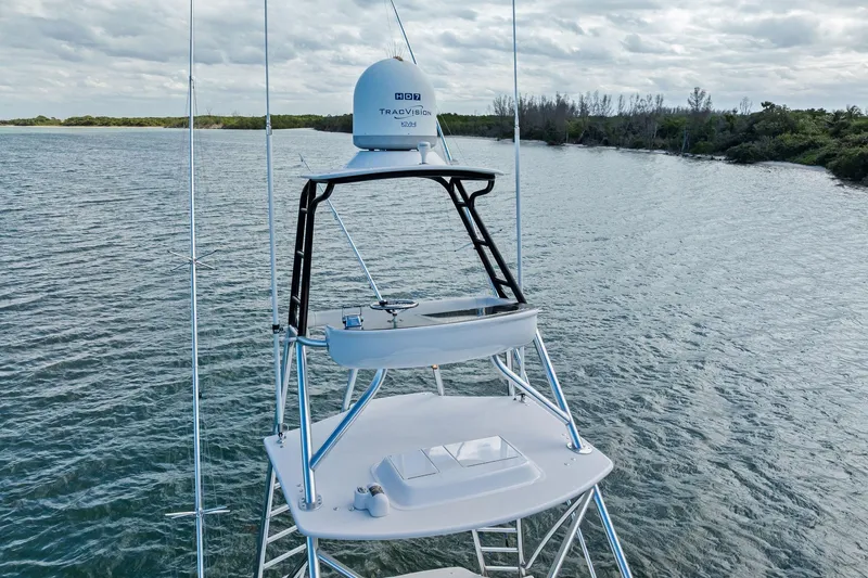 Slide: The Image of 2017 Spencer Convertible boat with radar tower on calm water, surrounded by lush greenery. - 17