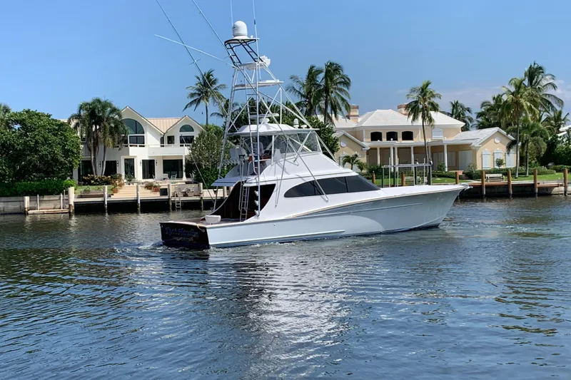 Slide: The Image of 2017 Spencer Convertible yacht cruising on open water under a partly cloudy sky. - 2