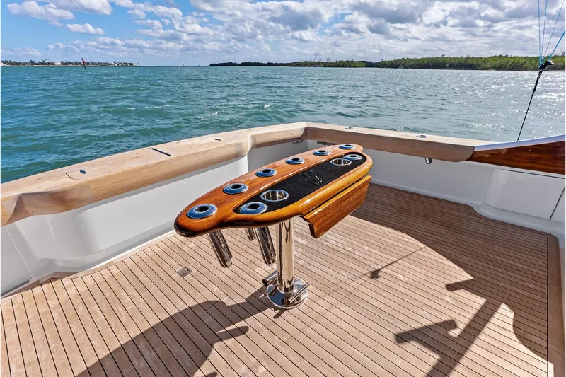 Slide: The Image of 2017 Spencer Convertible yacht deck with rod holders, overlooking serene ocean waters. - 25