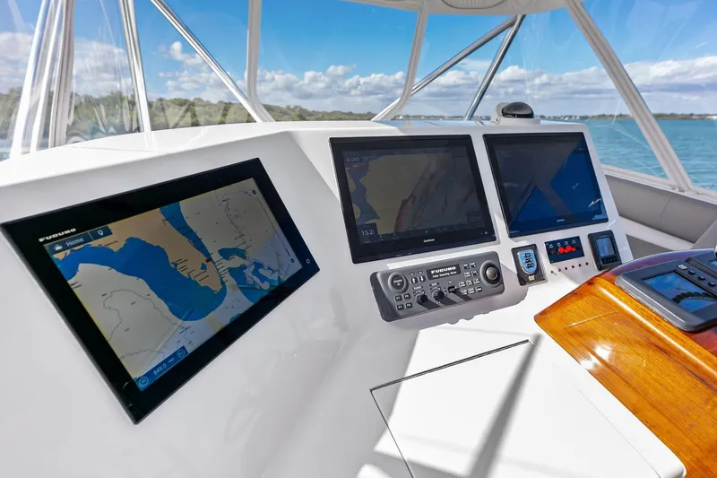 Slide: The Image of 2017 Spencer Convertible yacht dashboard with navigation screens and controls, overlooking serene waters. - 30