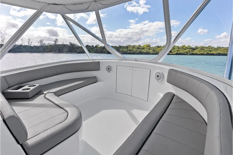 Slide: The Image of 2017 Spencer Convertible boat interior with gray seating, cup holders, and scenic water view. - 32