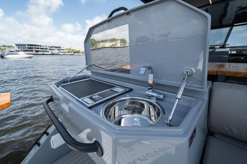 Slide: The Image of Outdoor kitchen on Hanover 387 boat, featuring sink and grill, with waterfront view. - 11