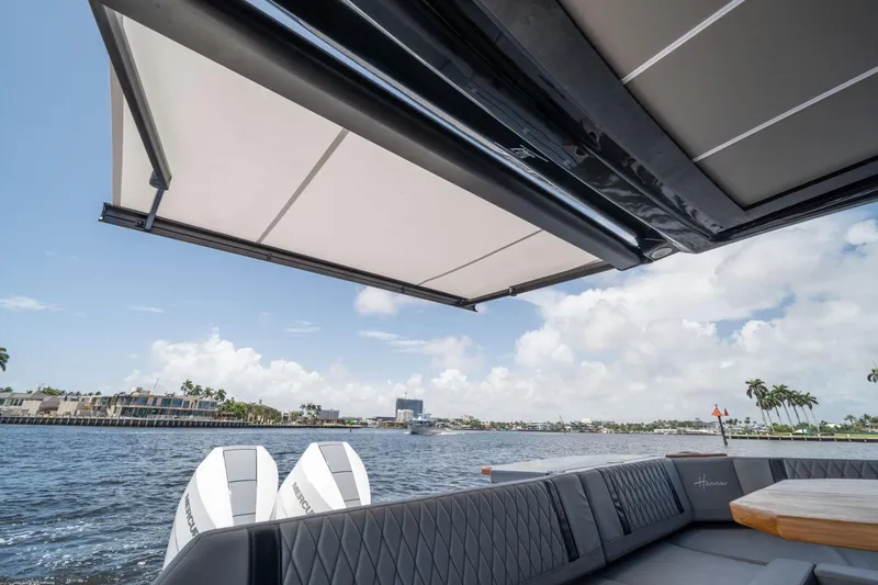 Slide: The Image of 2026 Hanover 387 boat with awning, luxurious seating, and scenic waterfront view. - 20