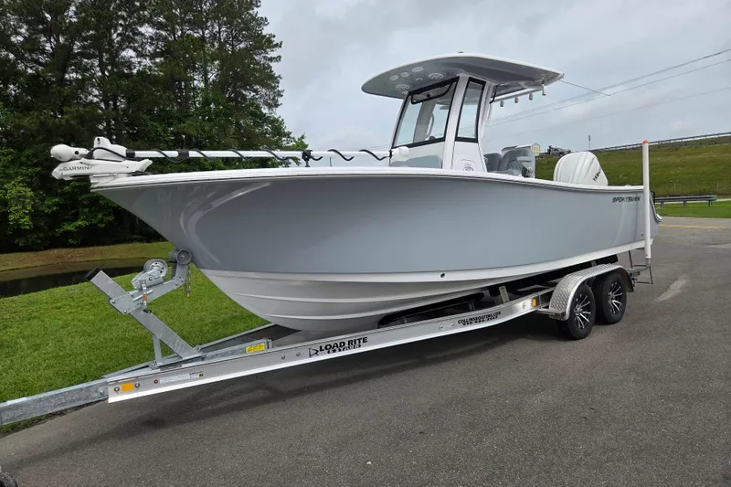 Slide: The Image of 2026 Sportsman Open 232 Center Console boat on trailer, parked outdoors. - 1