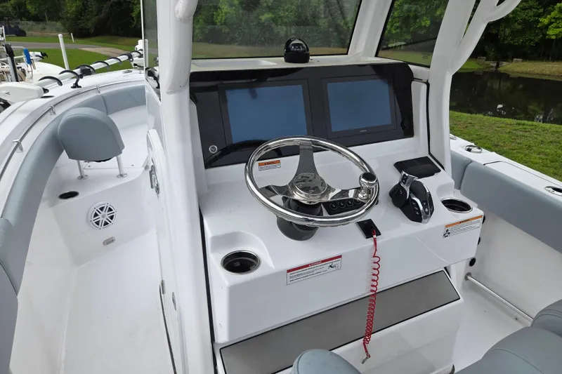 Slide: The Image of 2026 Sportsman Open 232 Center Console boat interior with steering wheel and dual screens. - 10