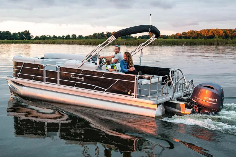 Slide: The Image of Manufacturer Provided Image: 2019 Sweetwater 2286 SFL pontoon boat cruising on a serene lake at sunset. - 12