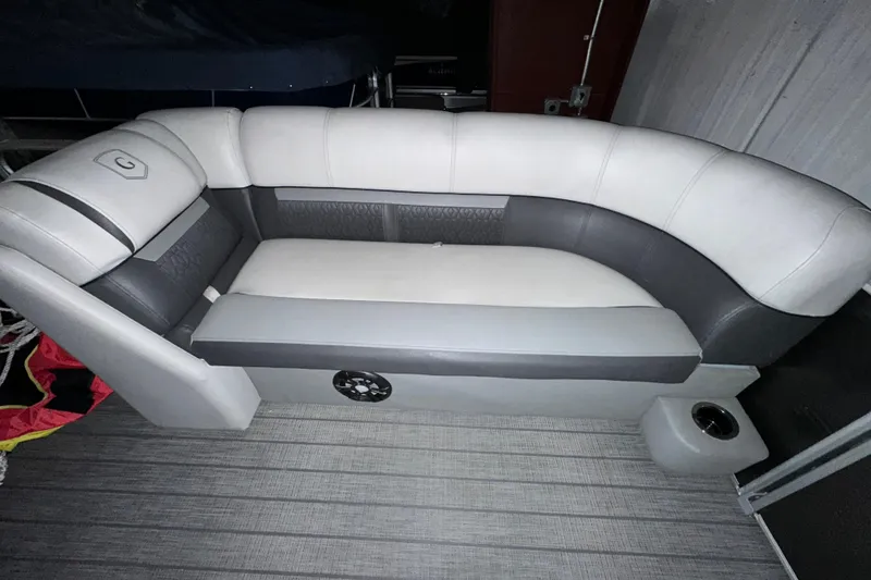 Slide: The Image of 2019 Sweetwater 2286 SFL boat seating with gray and white upholstery, cup holder, and speaker. - 2