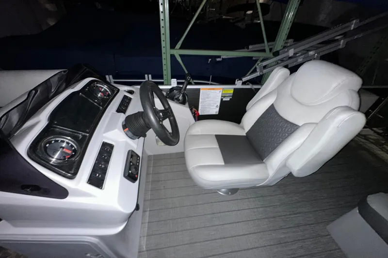 Slide: The Image of 2019 Sweetwater 2286 SFL boat interior with steering wheel and captain's chair. - 6