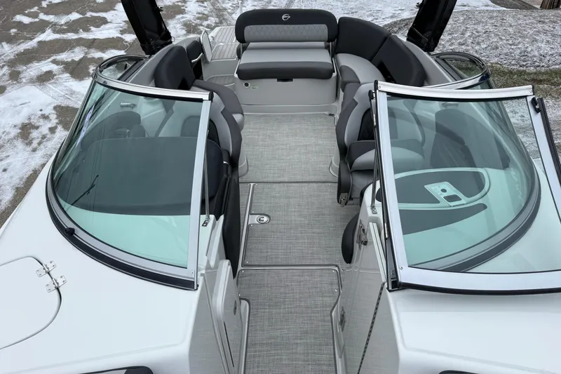 Slide: The Image of 2026 Crownline 288 SS boat interior with seating and windshield, parked on snowy ground. - 5