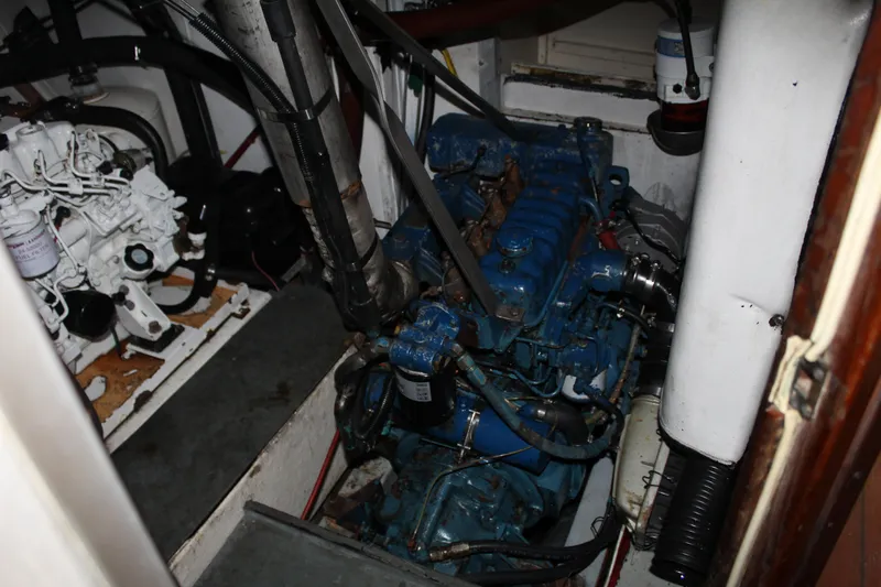 Slide: The Image of 1973 Gulfstar 41 Ketch CC engine room with blue engine and mechanical components. - 14