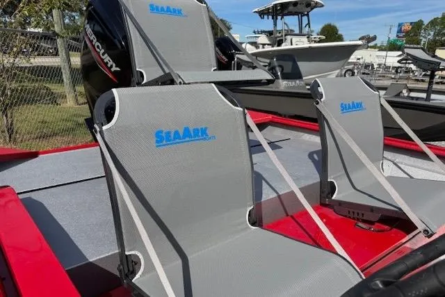 Slide: The Image of 2026 SeaArk Shadow 18 boat with gray seats and Mercury engine, docked outdoors. - 7