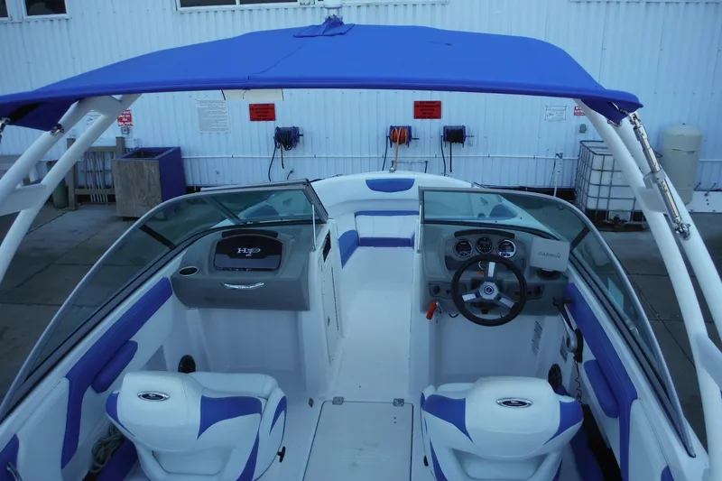 Slide: The Image of 2018 Chaparral 21 H2O Sport OB boat interior with blue accents and steering console. - 17
