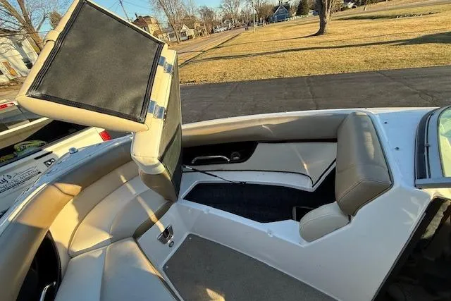 Slide: The Image of 2010 Regal 2300 Bowrider interior with beige seating and storage compartment. - 18