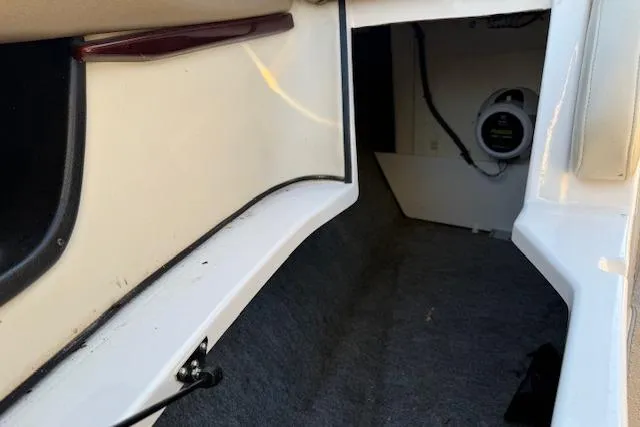 Slide: The Image of 2010 Regal 2300 Bowrider interior with beige seating and storage compartment. - 19