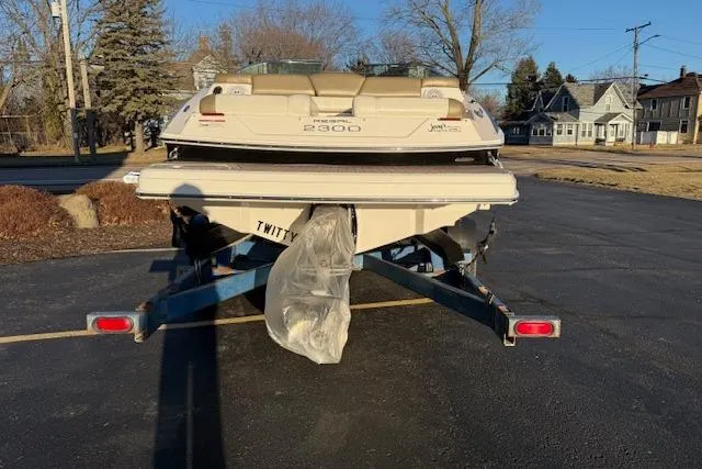Slide: The Image of 2010 Regal 2300 Bowrider boat on trailer in sunny parking lot. - 2
