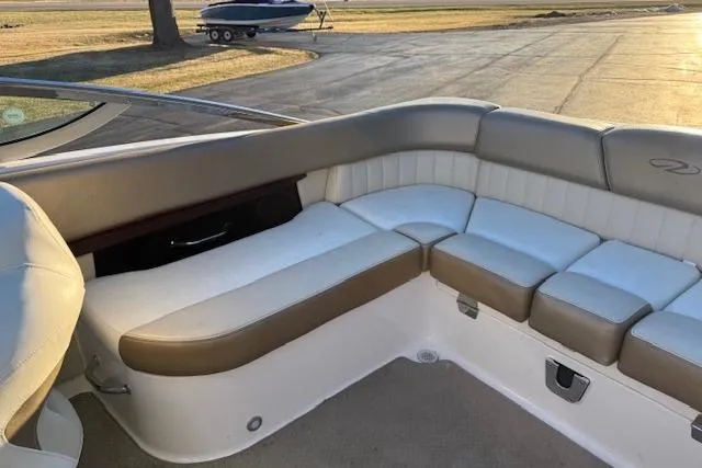 Slide: The Image of 2010 Regal 2300 Bowrider boat interior with open storage compartment and beige seating. - 26