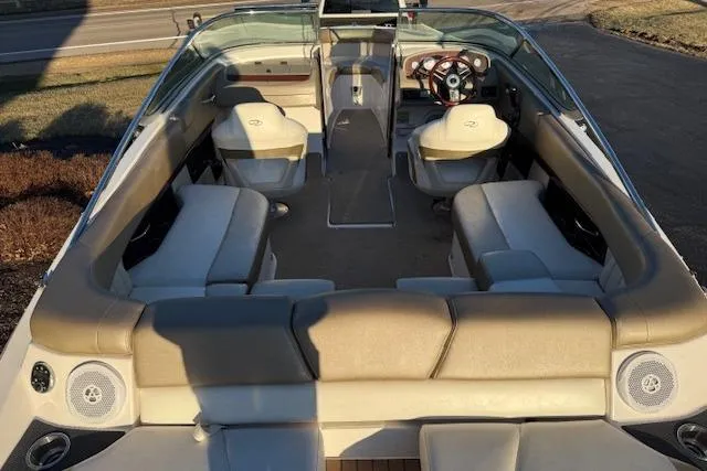 Slide: The Image of 2010 Regal 2300 Bowrider boat interior with beige seating and steering console. - 4