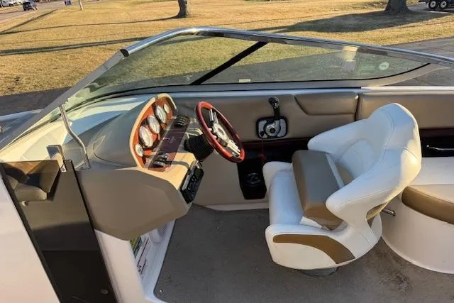 Slide: The Image of 2010 Regal 2300 Bowrider interior with steering wheel and dashboard, featuring white seating. - 6