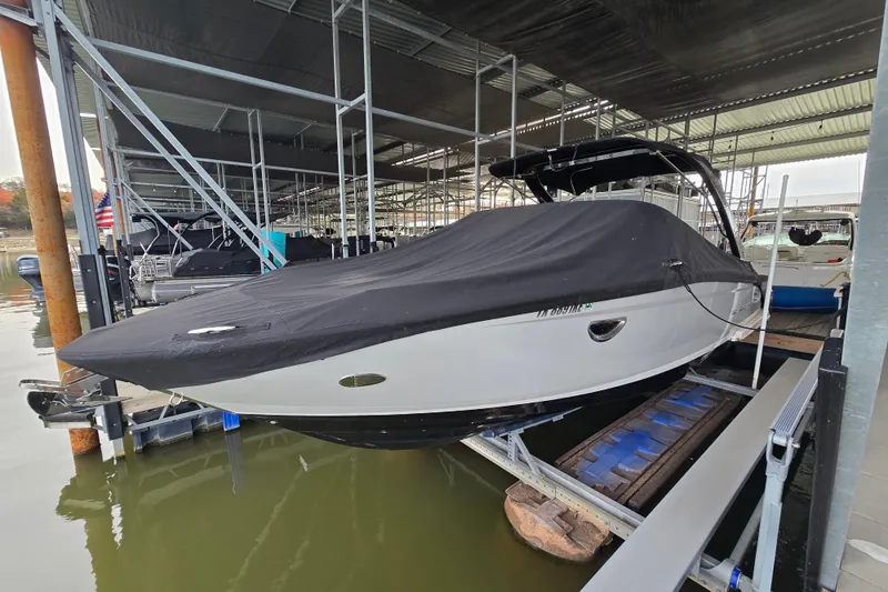 Slide: The Image of 2021 Regal 2800 Bowrider boat covered and docked in a marina. - 1