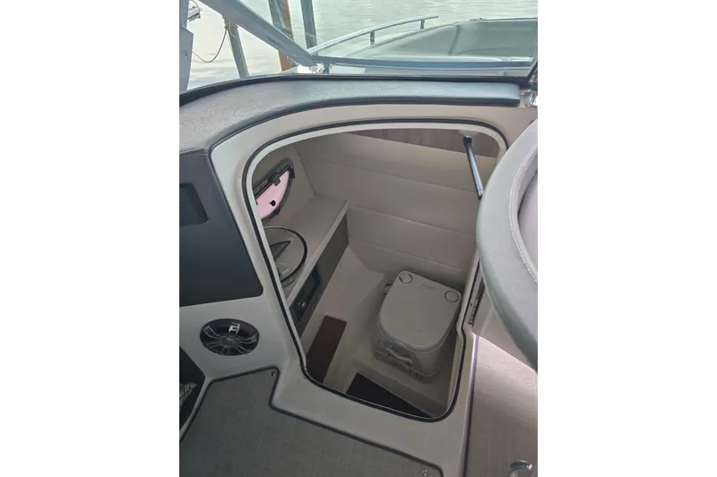 Slide: The Image of 2021 Regal 2800 Bowrider boat interior with compact toilet and storage area. - 18