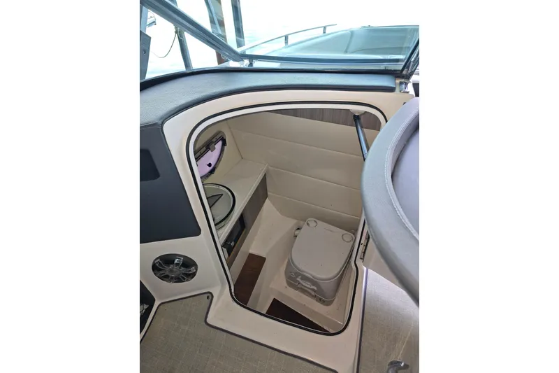 Slide: The Image of 2021 Regal 2800 Bowrider interior with compact marine toilet and storage space. - 19