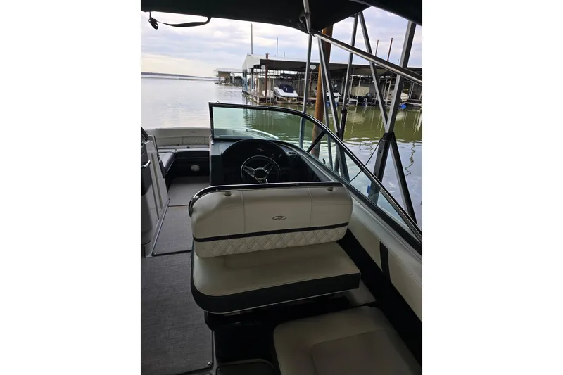 Slide: The Image of 2021 Regal 2800 Bowrider interior with steering wheel, docked by calm waters. - 23