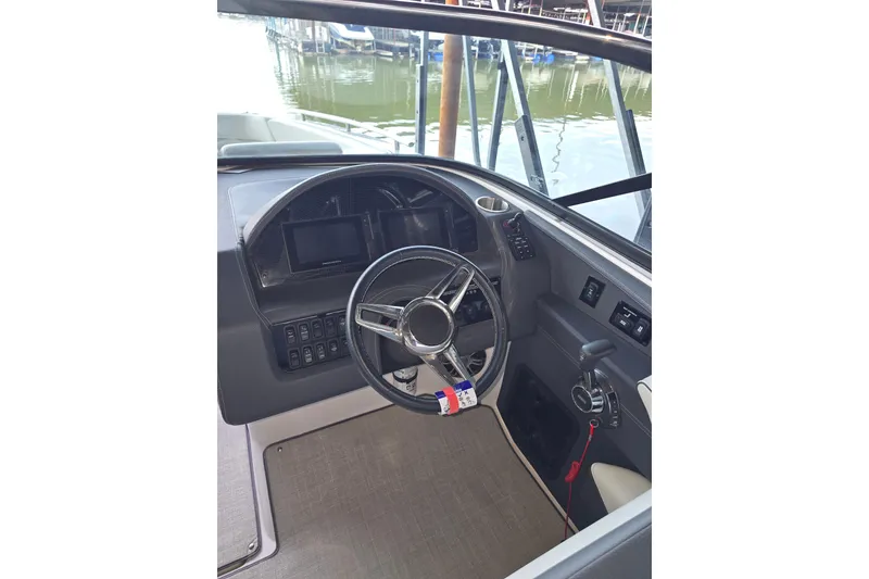 Slide: The Image of 2021 Regal 2800 Bowrider helm with steering wheel and control panel. - 24