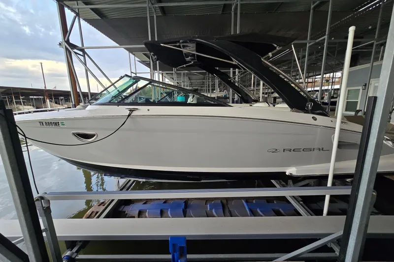 Slide: The Image of 2021 Regal 2800 Bowrider boat docked in a marina, side view. - 6
