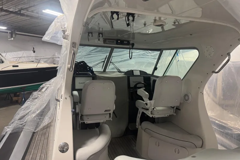 Slide: The Image of Interior of 2016 Protector Tauranga 41 boat with helm and seating in a storage facility. - 2
