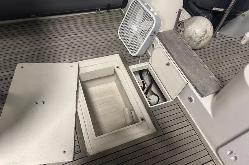 Slide: The Image of 2016 Protector Tauranga 41 boat deck with open storage compartments and fan. - 3