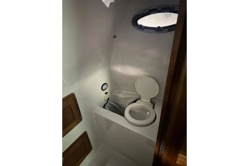 Slide: The Image of Bathroom interior of 2016 Protector Tauranga 41 boat, featuring a compact marine toilet. - 4