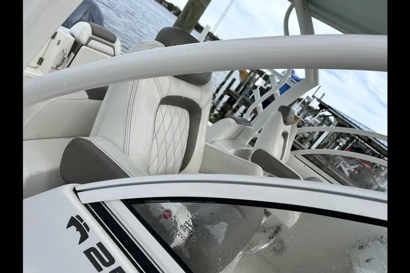 Slide: The Image of 2022 World Cat 255 DC boat interior with white seating and waterfront view. - 10