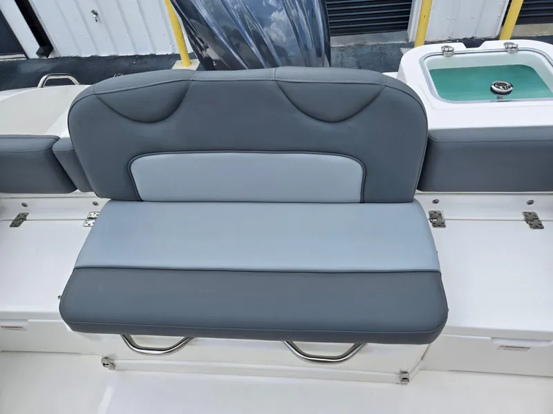 Slide: The Image of 2023 NauticStar 242L Offshore boat seat with gray upholstery and storage underneath. - 9
