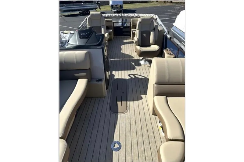 Slide: The Image of 2025 Veranda Relax VR 22 RC pontoon boat interior with beige seating and wood-style flooring. - 3