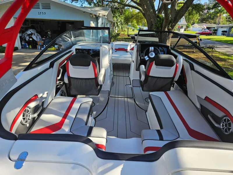Slide: The Image of 2020 Yamaha Boats 242X interior with red and white seating, steering wheel, and open layout. - 16