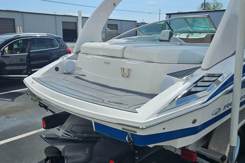 Slide: The Image of 2014 Regal 2100 Bowrider boat with swim platform and seating, parked on a trailer. - 11