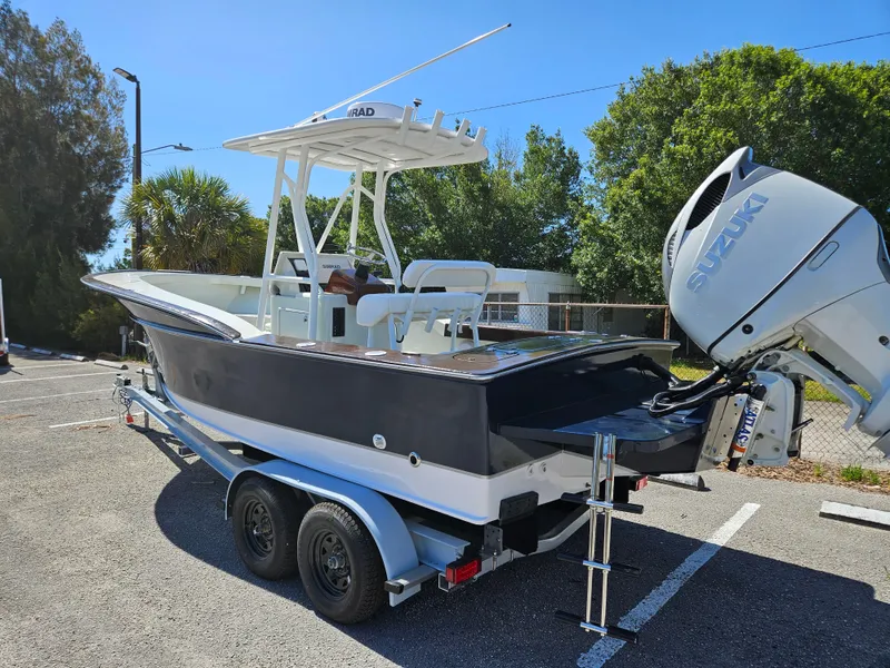 The Image of 2023 Carolina Classic 25 boat on a trailer with Suzuki outboard motor. - 1