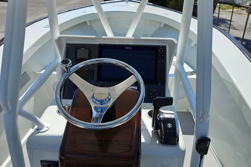Slide: The Image of 2023 Carolina Classic 25 boat helm with steering wheel and control panel. - 11
